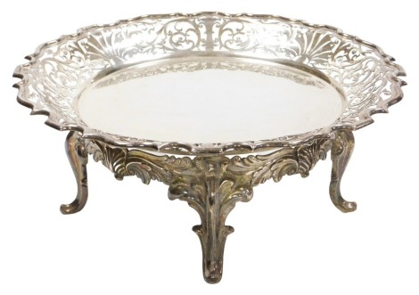 An Edward VII silver cake stand, the bowl with pierced Acanthus leaf and foliate scroll decoration, with a pie crust rim, raised on a foliate scroll base, with four scroll feet, Walker and Hall, Sheffield 1910, 37.06oz, 31cm wide.