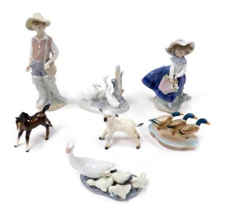 A Lladro porcelain figure of a girl with a basket of flowers, another of a boy, Lladro and Nao groups of ducks and ducklings, Beswick sheep etc. (qty)(AF)