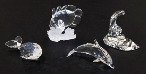 Three Swarovski crystal figures, boxed with certificates, comprising a whale, fish on coral, and a dolphin riding a crest of a wave.