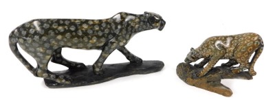 An African carved hardstone figure of a leopard, raised on a naturalistic base, 25cm wide, and a further figure of a leopard, standing upon a rock, 13cm wide. (2)