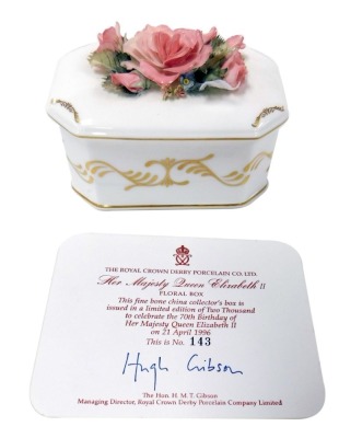 A Royal Crown Derby porcelain floral box, commemorating Her Majesty Queen Elizabeth II's 70th birthday, limited edition 143/2000, with certificate, signed by Hugh Gibson, 11cm wide.