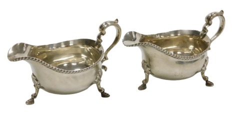 A pair of George V silver sauce boats, with a gadrooned rim, and double scroll handle, raised on three hoof feet, Sheffield 1929, 17.26oz.