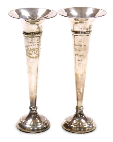 A near pair of Elizabeth II silver loaded bud vases, of trumpet form, presentation engraved, Birmingham 1966 and 1969, 7.81oz.