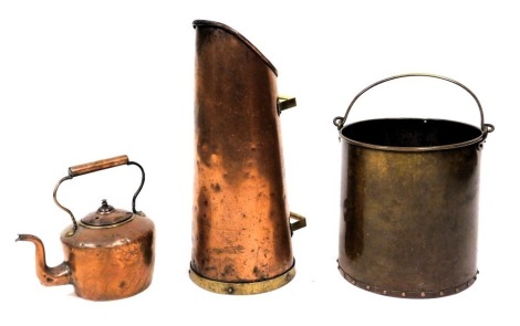 An early 20thC copper coal or log bucket, of cylindrical form, with swing handle, 30cm high, copper and brass coal scuttle, 53cm high, and a copper kettle. (3)