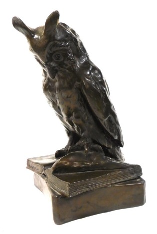 A bronzed plaster figure of a wise owl, modelled perched on an open book and irregular square base, 30cm high.