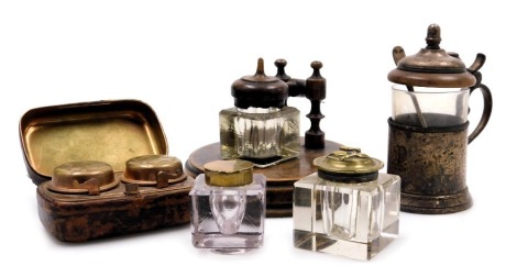 A late 19thC novelty glass and wooden inkwell on stand, the hinged lid formed as a gavel, 11.5cm wide, two cut glass inkwells with hinged brass lids, a leather bound travelling double inkwell, and a Christofle silver plate and cut glass tea glass and hold