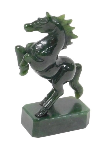 A jade figure of a prancing horse, raised on a canted rectangular base, 13cm high.