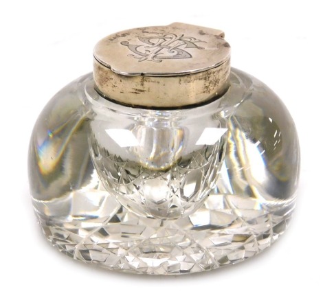 An Edward VII cut glass and silver mounted inkwell, with a hinged lid, monogram engraved, London 1902.