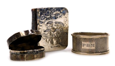 A miniature common prayer book, with a silver front cover, embossed with cherubim, Birmingham 1904, George VI silver napkin ring, with engine turned decoration, Birmingham 1947, 0.46oz, and a silver pill box, of serpentine form, monogram engraved, Birming