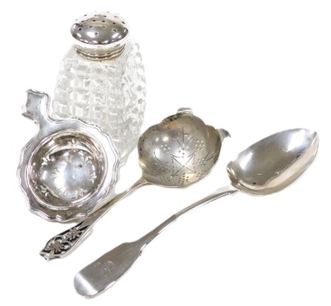 An Elizabeth II silver tea strainer, Birmingham 1985, further tea strainer, Sheffield 1966, a George IV silver dessert spoon, monogram engraved, London 1826, and an Edward VII cut glass sugar sifter, with silver lid, Birmingham 1907, 4.12oz.