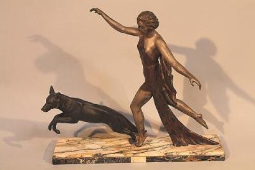 An Art Deco style cast metal figure group of a woman with an Alsatian