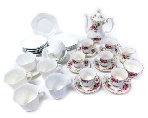 A Royal Albert porcelain Moss Rose pattern part coffee service, comprising coffee pot, cream jug, sugar bowl, six cups and saucers, together with a Shelley white glaze porcelain part tea service with fan shape fluting, comprising six tea cups, eight sauce