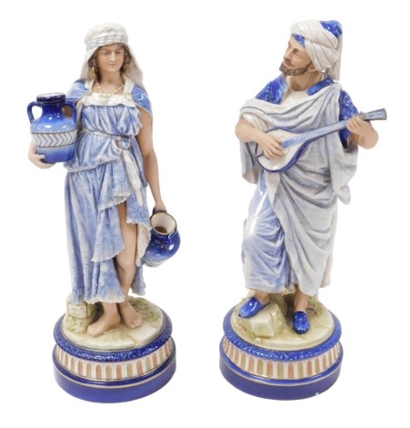 A pair of late 19thC Continental porcelain figures, of a North African gentleman playing a lute, and a woman water carrier, each raised on a circular base, 38cm high. (AF)