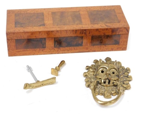 A satinwood and burl walnut glove box, 28.5cm wide, together with a brass copy of the Sanctuary Ring door knocker at Durham cathedral, 16cm high. (2)