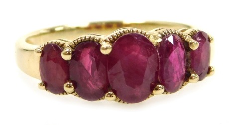 A ruby five stone ring, possibly Burmese, of graduated size, set in unmarked yellow metal, size P, 2.9g.