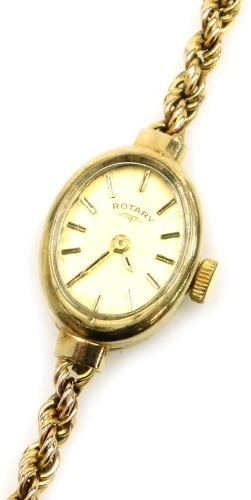 A Rotary lady's 9ct gold cased wristwatch, oval champagne dial with gilt batons, in an oval casing, on a 9ct gold rope twist strap, 14.5g all in.