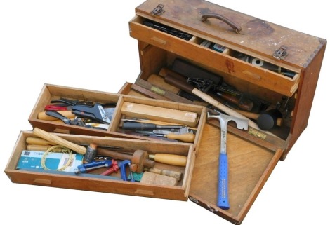 A carpenter's tool chest, the drop front opening to reveal three drawers and a recess, enclosing various tools, 63cm wide.