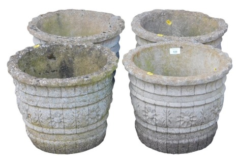 Four circular concrete planters, decorated with a band of flower heads, 30cm high, 38cm wide.