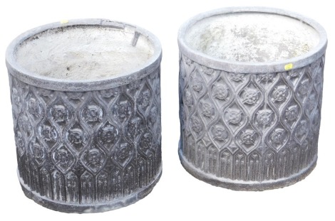 A pair of black cylindrical fibreglass planters, with a repeated floral motif design, 43cm high, 45cm wide.