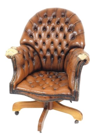 A mahogany and tan leather swivel office chair, 75cm wide.