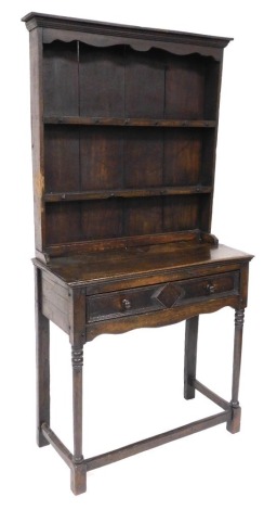 An 18thC and later oak dresser, the plate rack with an outswept pediment over two shelves with hanging hooks, above a base with frieze drawer, raised on partially bobbin turned legs, united by a box stretcher, 184cm high, 91cm wide, 42cm deep.