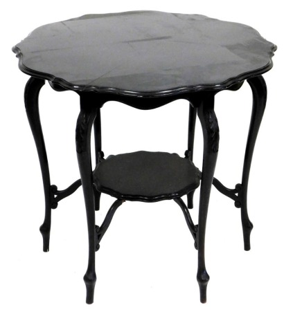 An Edwardian ebonised window or occasional table, the circular top with a shaped moulded edge, on leaf carved cabriole legs united by an under tier, 69cm high, 77cm wide.