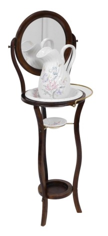 A Victorian style oak wash stand, with a circular swing frame mirror above a stand enclosing a china bowl, on four slender cabriole legs united by an under tier, with a wash jug, 130cm high.