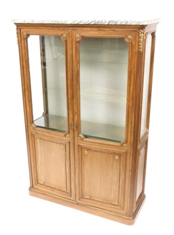 An French Empire style marble topped kingwood vitrine, with two glazed and panelled doors enclosing two glass shelves, raised on a plinth base, 150cm high, 101cm wide, 39cm deep.