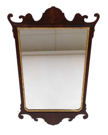 A Georgian style mahogany and parcel-gilt fretwork wall mirror, with a rectangular mirrored plate, 98cm wide, 61cm wide.