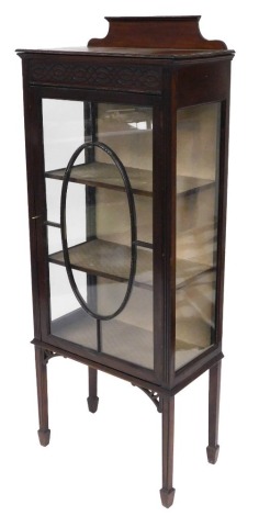 An early 20thC Chippendale style mahogany display cabinet, with blind fret work over a glazed door enclosing two shelves, on tapering square legs and spade feet, 150cm high, 59cm wide, 31cm deep.