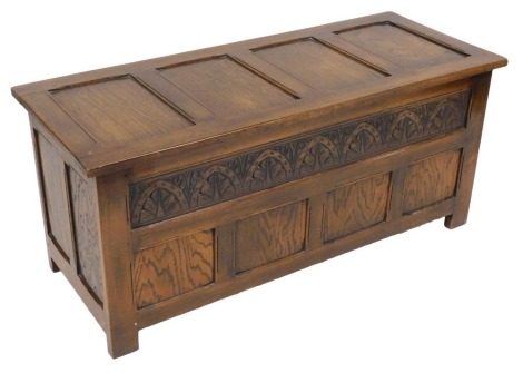 A Reprodux oak blanket chest, with a foliate carved front, 53cm high, 119cm wide, 48cm deep.