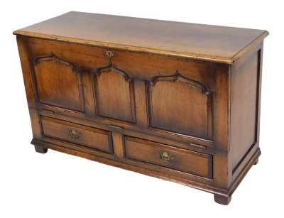 An oak rule chest, possibly Titchmarsh and Goodwin, with a hinged lid and panelled front, over two frieze drawers, raised on stiles, 72cm high, 121cm wide, 46.5cm deep.