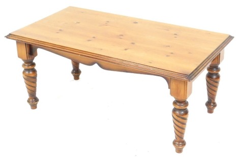 A pine coffee table, with a rectangular top, over a shaped apron, raised on turned and spiral fluted legs, 38cm high, 87cm wide, 47cm deep.