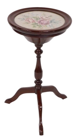 A Victorian mahogany sewing table, with a circular floral wool work inlaid top, opening to reveal a vacant interior, above a turned column, on three cabriole legs, 62.5cm x 42cm.