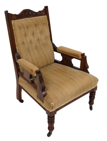 A Victorian walnut ladies amrchair chair, upholstered in light brown button back fabric, raised on turned legs, brass capped on castors, 64cm wide.