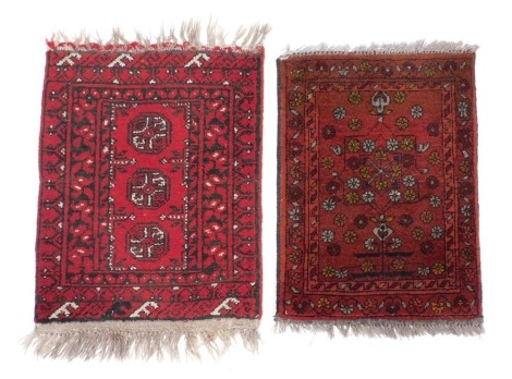 An Afghan red ground rug, with floral decoration, 66cm x 46cm, and a further red ground prayer rug with three central medallions, 77cm x 50cm. (2)