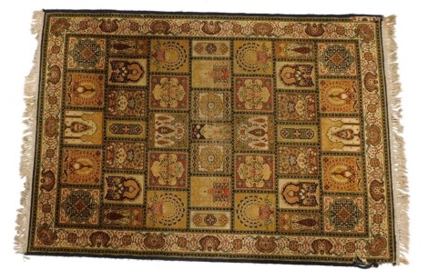 A Persian Bakhtiyari brown ground rug, with a field of compartments containing peacocks, mosques, trees and flowers, within a repeating floral border, 215cm x 142cm.