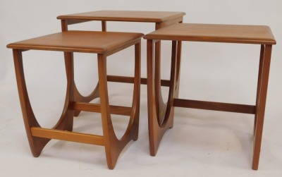 A nest of three G-Plan teak tables, each square top raised on a U shaped end support united by stretcher, the largest 51cm high, the top 50cm x 50cm. - 2