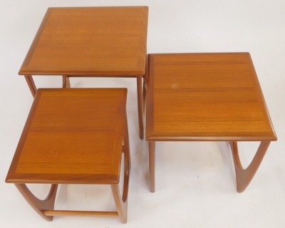 A nest of three G-Plan teak tables, each square top raised on a U shaped end support united by stretcher, the largest 51cm high, the top 50cm x 50cm. - 3