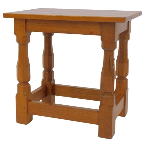 A Robert Mouseman Thompson of Kilburn oak stool, the rectangular top raised on four square legs, one carved with mouse, united by stretchers, 38cm high, the top 41cm x 28cm.