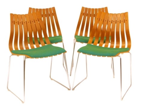 A set of four Hans Brattrud for Hove Mobler teak chairs, each with a slatted back and seat, with a green fabric seat, on U shaped chrome legs.