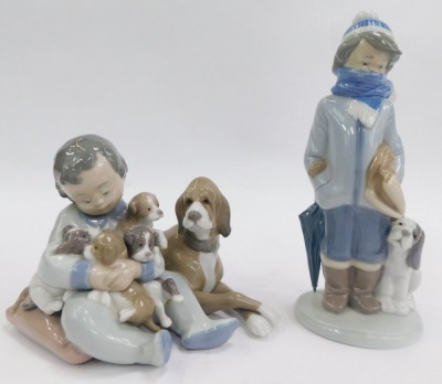 A group of Lladro porcelain figures, comprising boy seated beside dog and puppies, impressed number 5456, 12cm high, boy wearing coat beside a dog, 20cm high, and polar bear, 12cm high. - 2