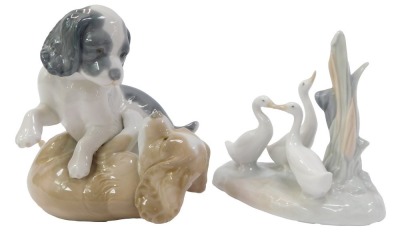 Two pieces of Nao porcelain figures, comprising two dogs playing, 13cm high, and a group of geese beside tree bough, 12cm high, printed marks.