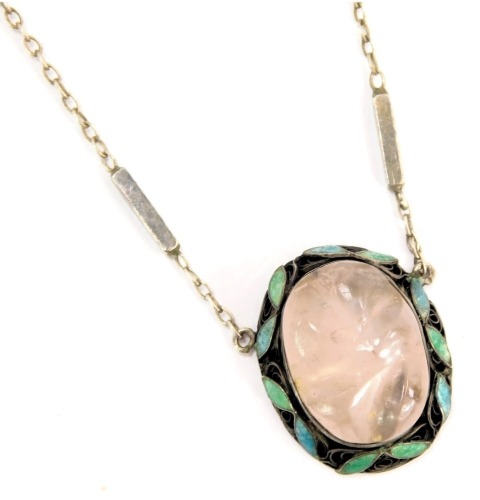 A 1950s/60s pendant and chain, the oval pendant with blue and green leaf enamel, with central carved rose quartz, on a white metal chain stamped 925, the pendant 2.5cm high, the chain 40cm long, 7.5g all in.