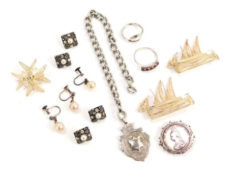 A group of silver and other jewellery, comprising a part silver curb link watch chain with crest shield, a Victoria 1887 brooch, two silver dress rings, 39g, a group of filigree boat brooches, buttons, drop earrings, etc.