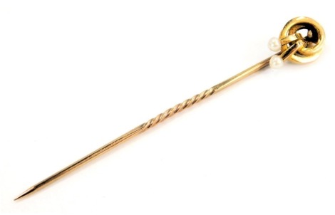 An Edwardian stick pin, the top with two interlinked circles and drop seed pearls stamped 15ct, in a W Davis and Sons of Brighton fitted box, 5.5cm high, 1.2g all in.