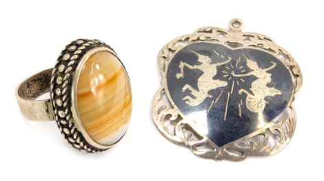 A pendant and a dress ring, comprising an Eastern inspired pendant, depicting two warriors, yellow metal stamped 925, 5cm high, and a dress ring, with chunky design and oval agate, rubbed marking possibly silver, 34.3g all in. (2)