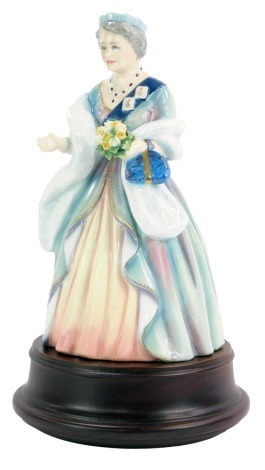 A Royal Doulton porcelain figure modelled as Queen Elizabeth The Queen Mother, to Celebrate Her 90th Birthday 4th August 1990, limited edition number 1416/2500, on wooden stand.