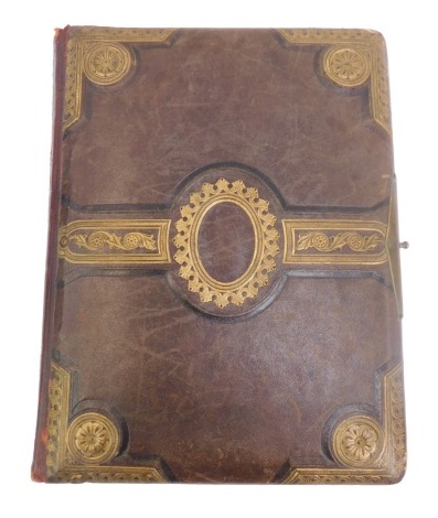 A Victorian photograph album, circa 1910 and later, with brown leather and gilt tooled binding, opening to reveal black and white family photographs and portraits. (1 album)