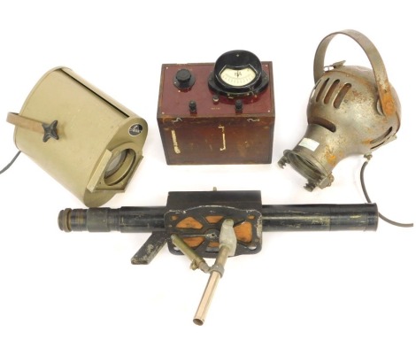 A Furse vintage spotlight, a World War II periscope, mounted on a wooden block, further military spotlight and a volt meter. (4)